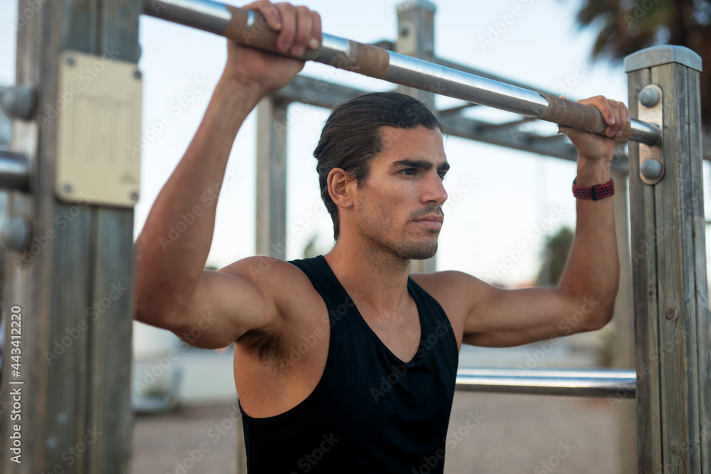 Sporty athletic man exercises at the beach. Handsome man training outdoors.. Sporty athletic man exercises at the beach. Handsome man training outdoors..