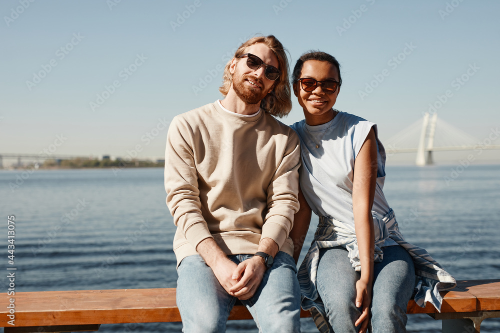 Portrait of contemporary young couple looking at camera while posing by river outdoors, copy space