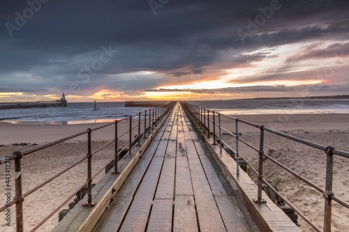 A glorious morning at Blyth beach  with a beautiful sunrise over the old wooden Pier stretching out to the North Sea