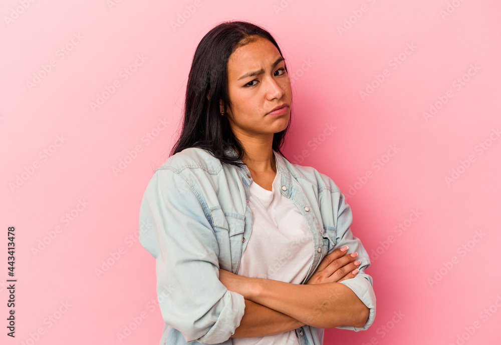 Young Venezuelan woman isolated on pink background suspicious, uncertain, examining you. Young Venezuelan woman isolated on pink background suspicious, uncertain, examining you.