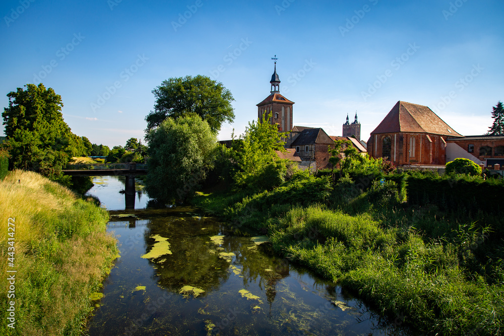 Seehausen in der Altmark, Sachsen-Anhalt, Deutschland. Der Fluss Aland fließt vorbei an der Alzkirche und dem Beuster Tor im Sommer. Hinten ist die Kirche St. Petri zu sehen.