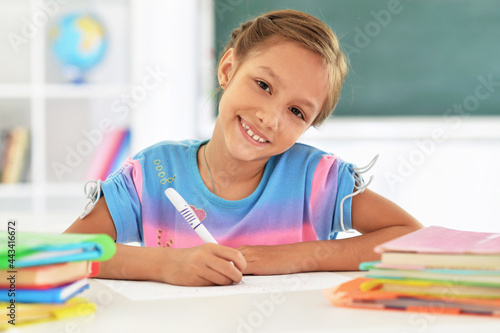 Portrait of cute little girl drawing at home
