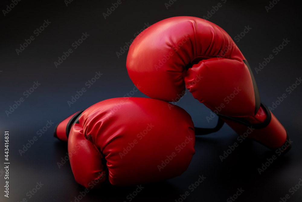 Pair of red leather boxing gloves on black background.