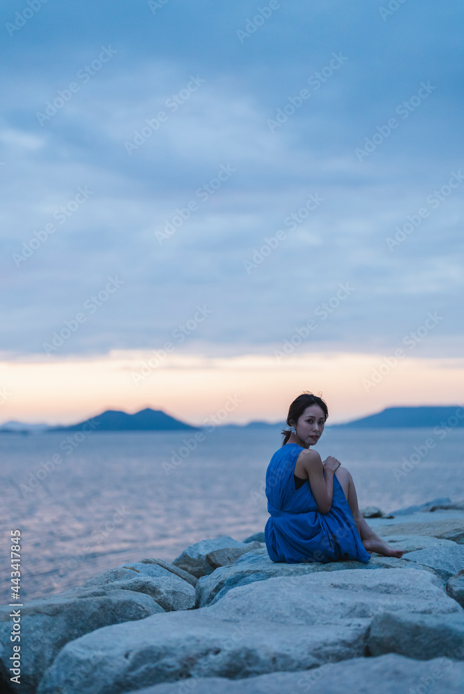 夕暮れの海にいる女性