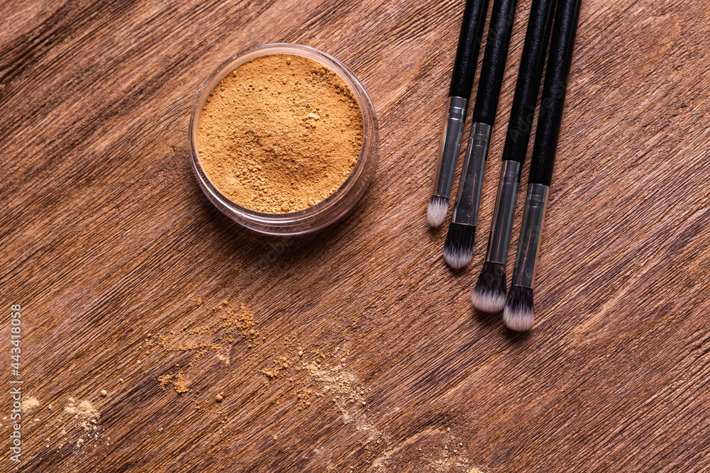 Mineral powder foundation with brushes on a wooden background. Eco-friendly and organic beauty products