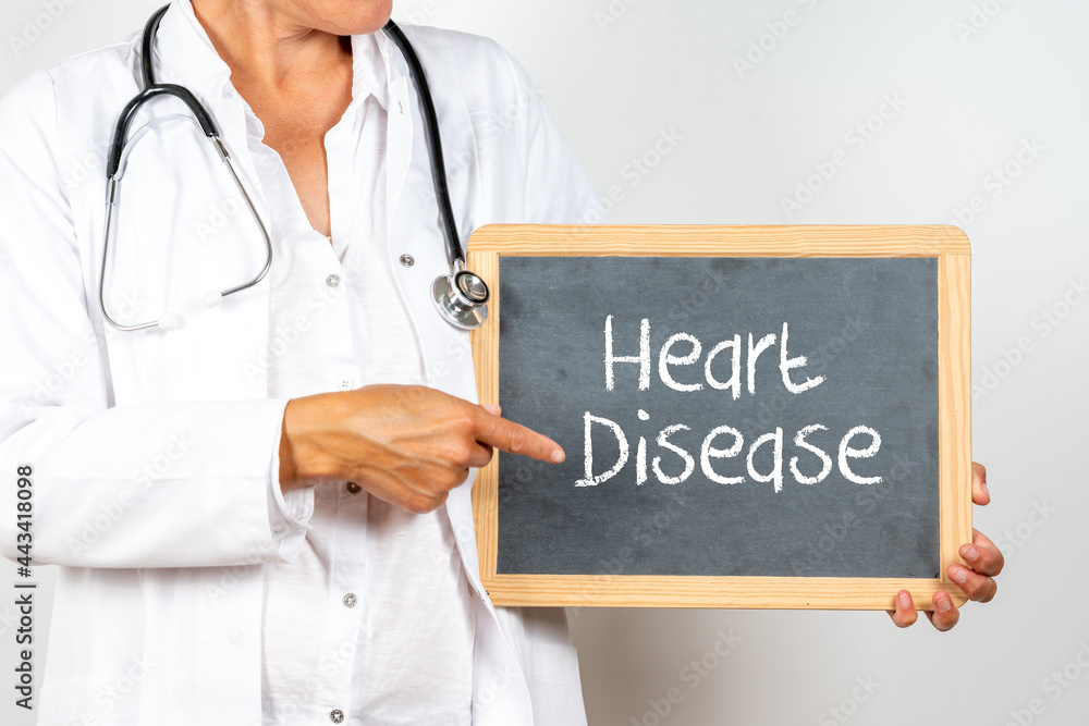 Doctor holding a blackboard with Heart Disease text Doctor holding a blackboard with Heart Disease text