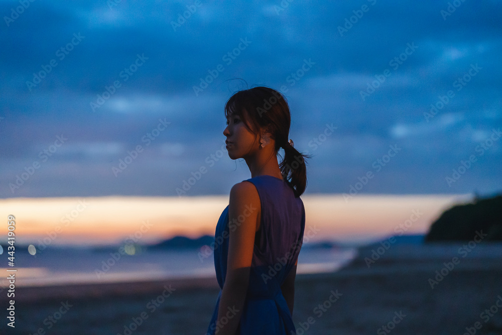 夕暮れの海にいる女性