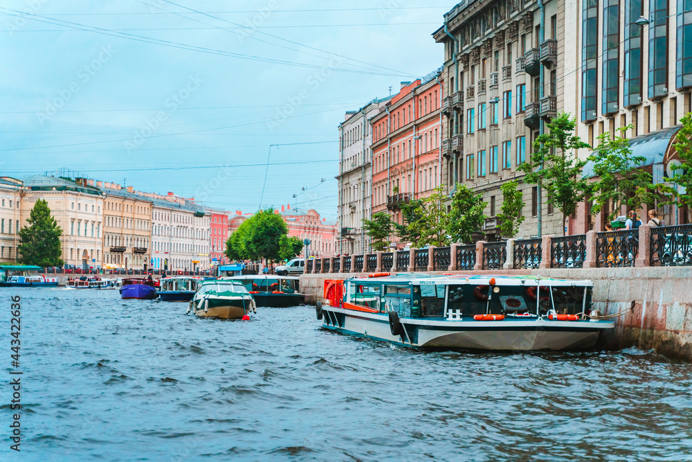 Fototapeta premium Beautiful view of the Neva river canal in the city center with tourist excursion boats, postcard view. Saint Petersburg, Russia - 28 June 2021