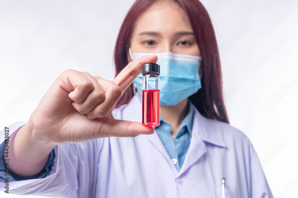 Hand of woman doctor wear uniform white clothes and medical mask protection virus disease on nose while holding test tube with blood sample over isolated white background. Select focus
