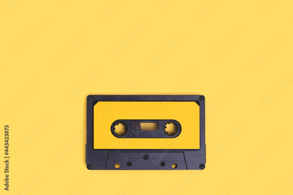 Fototapeta premium Cassette tape on a yellow background with copy space.