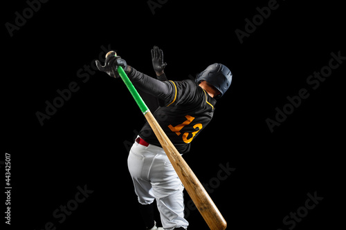 Canvas Print Professional baseball player, pitcher in sports uniform and equipment playing baseball isolated on black studio background in neon light