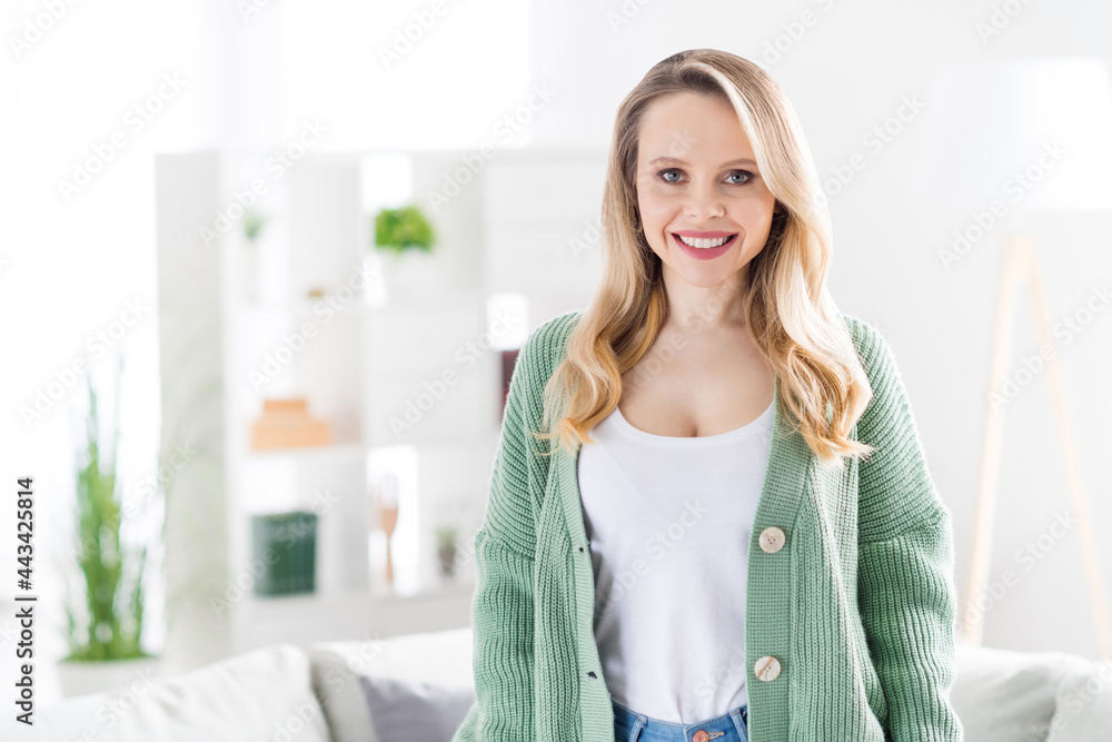 Naklejka premium Portrait of attractive cheerful wavy-haired girl wearing cozy clothes staying at home light white house flat room indoors