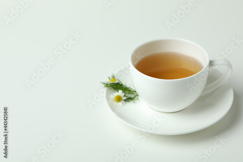 Cup of chamomile tea on white background