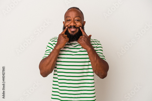 African american man with beard isolated on pink background doubting between two options.