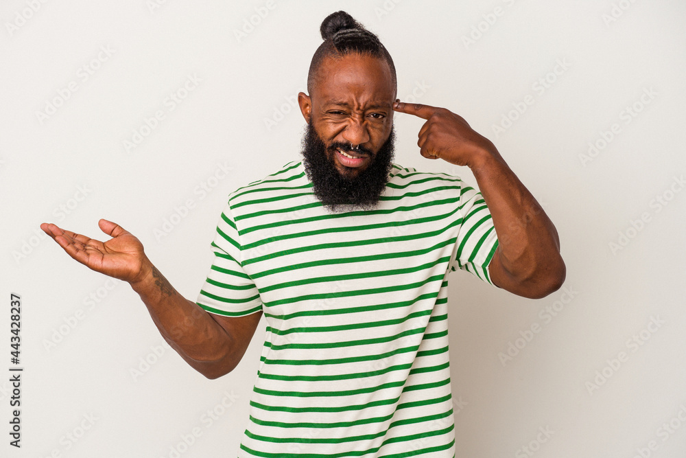 African american man with beard isolated on pink background holding and showing a product on hand. African american man with beard isolated on pink background holding and showing a product on hand.