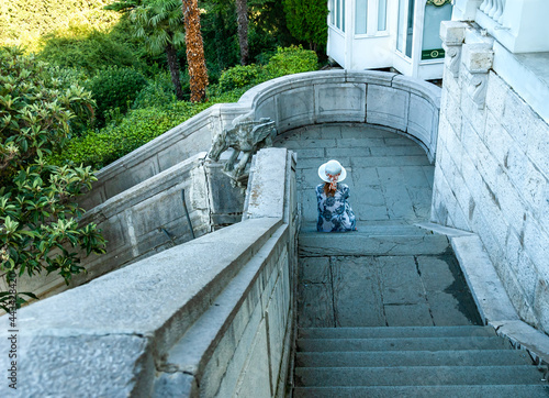 A girl is sitting on the stairs of the royal palace in Livadia. Yalta, Crimea.