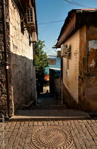 A shady street of a seaside town. The inscription on the sign – 