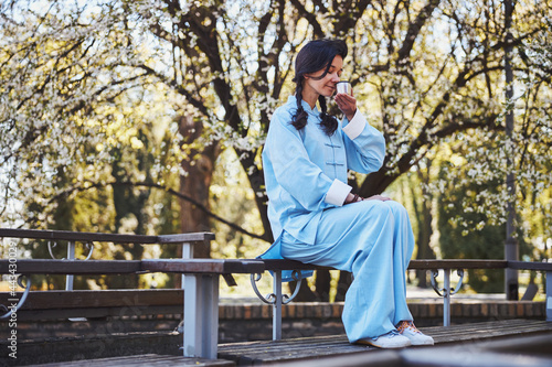 Female martial artist smelling her dring while sitting on bench