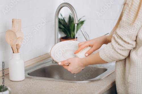 Woman washes dishes by eco brush.Zero waste photo