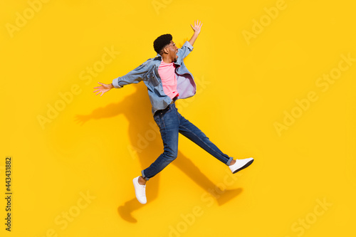 Full body photo of afro american young man jump up look empty space crazy isolated on yellow color background