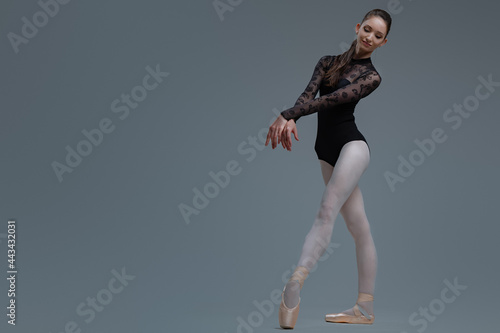 Fototapeta Naklejka Na Ścianę i Meble -  Ballet dancer in black tutu dancing inside studio