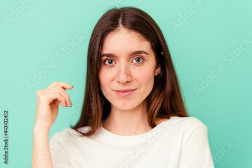 Young caucasian woman isolated on blue background
