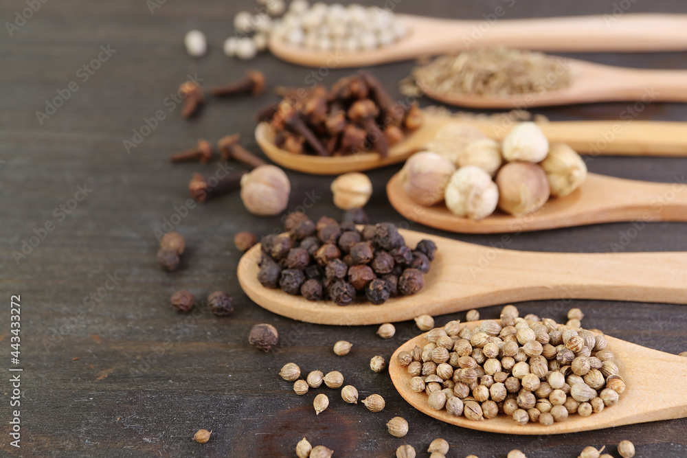Assortment of spices in spoons on wooden background Assortment of spices in spoons on wooden background