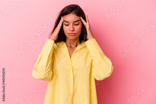 Young caucasian woman isolated on pink background touching temples and having headache.