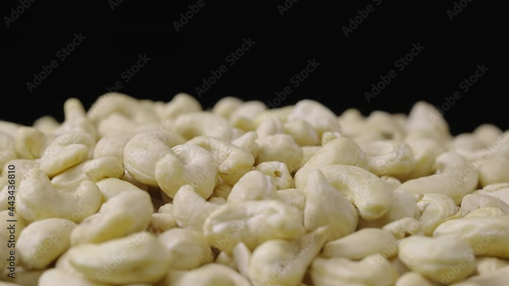 A handful of fresh cashews rotate on a black background. Kernels of delicious healthy nuts close up. Nutty background, healthy food, diet. Slow motion ready 59.94fps. A handful of fresh cashews rotate on a black background. Kernels of delicious healthy nuts close up. Nutty background, healthy food, diet. Slow motion ready 59.94fps.