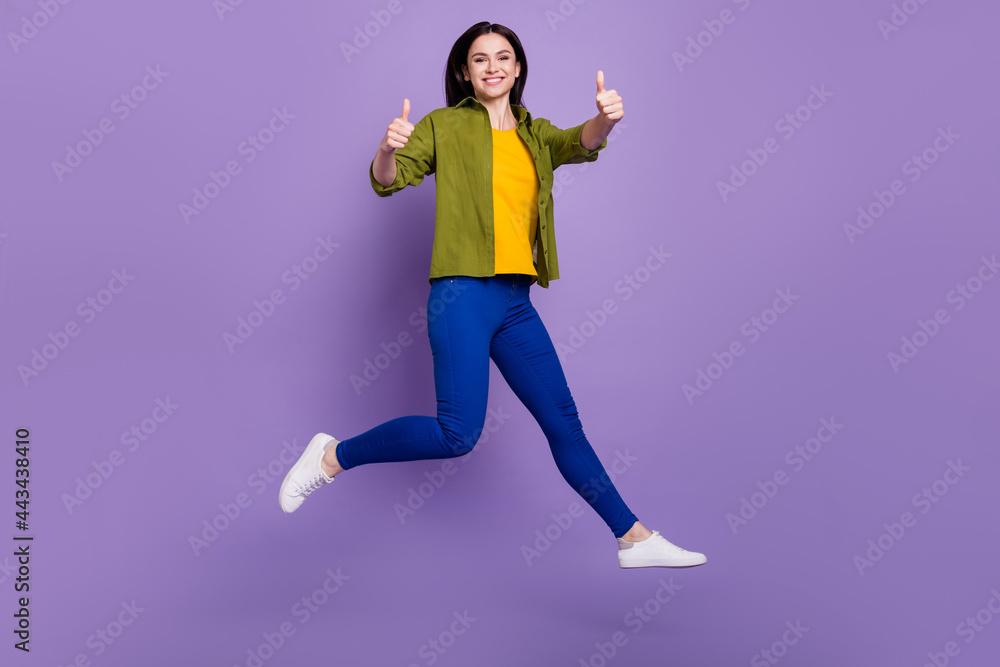 Full size profile side photo of young girl happy positive smile jump show thumb-up like cool isolated over violet color background