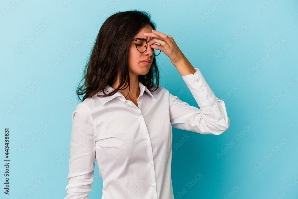 Young caucasian woman isolated on blue background having a head ache, touching front of the face. Young caucasian woman isolated on blue background having a head ache, touching front of the face.