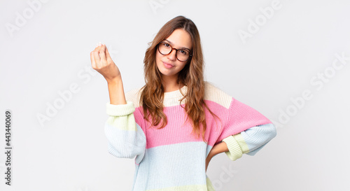 young pretty woman making capice or money gesture, telling you to pay photo