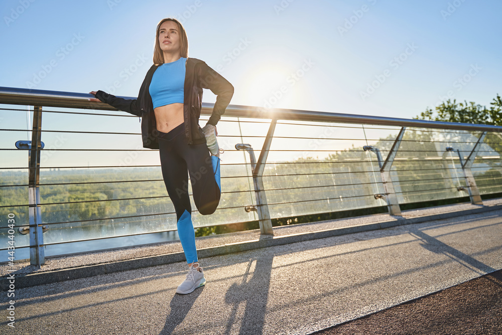 Obraz premium Young atheletic woman going training on urban bridge