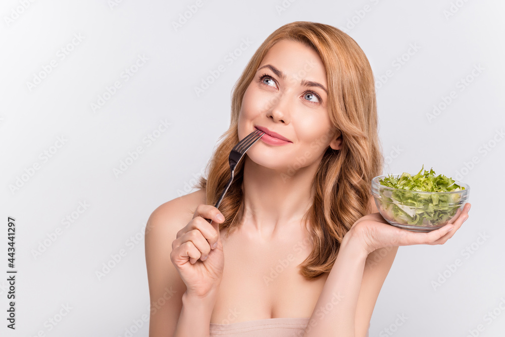 Portrait of attractive dreamy hungry cheerful woman eating tasty salad copy space isolated over grey pastel color background Portrait of attractive dreamy hungry cheerful woman eating tasty salad copy space isolated over grey pastel color background