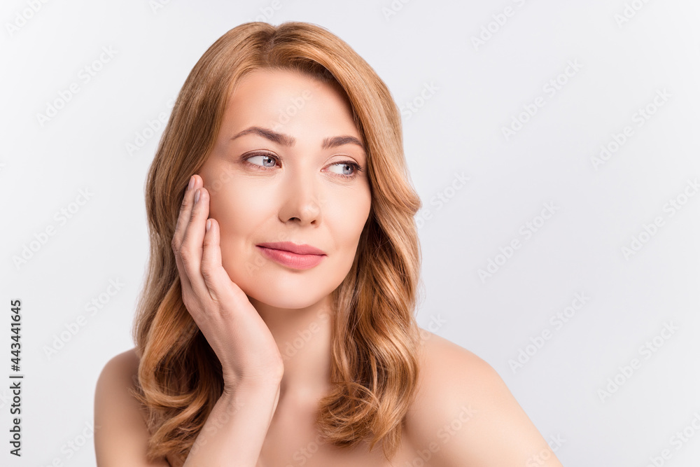 Portrait of attractive dreamy woman touching pure soft smooth skin isolated over grey pastel color background Portrait of attractive dreamy woman touching pure soft smooth skin isolated over grey pastel color background