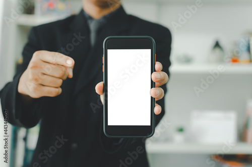 Businessman holding a blank white touch screen smartphone. Used to put text or information to advertise news or sell products online. concept marketing business