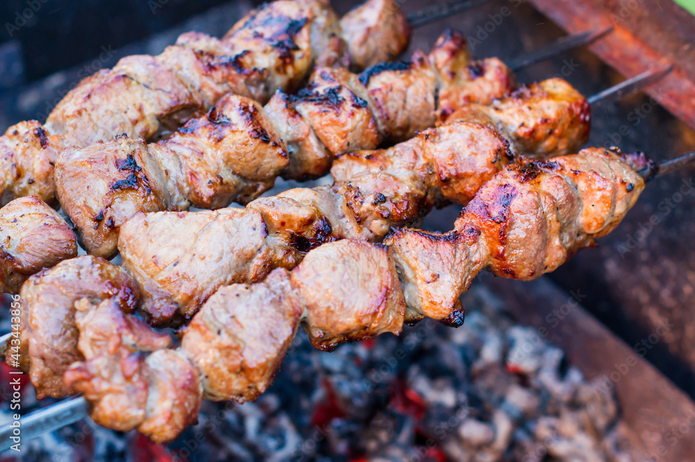 shish kebab in the open air on the grill. cooking meat on the street. street food. picnic. family rest. heat from coals on the grill. Shish kebab from pork shish kebab in the open air on the grill. cooking meat on the street. street food. picnic. family rest. heat from coals on the grill. Shish kebab from pork