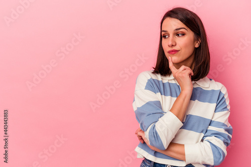 Fotografia Young caucasian woman isolated on pink background looking sideways with doubtful and skeptical expression