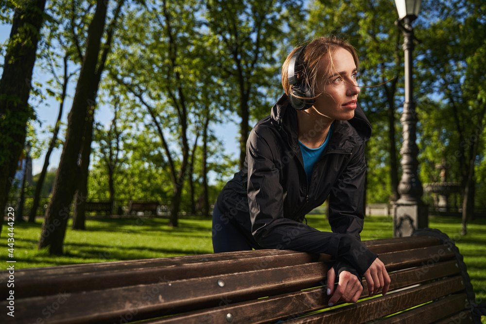 Fototapeta premium Happy young woman enjoying music in park