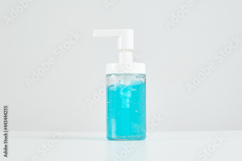 Close-up, blue alcohol in a clear plastic bottle on white background used to clean hands to prevent the spread of disease and infection of coronavirus (Covid-19) bacteria and for good health hygiene.