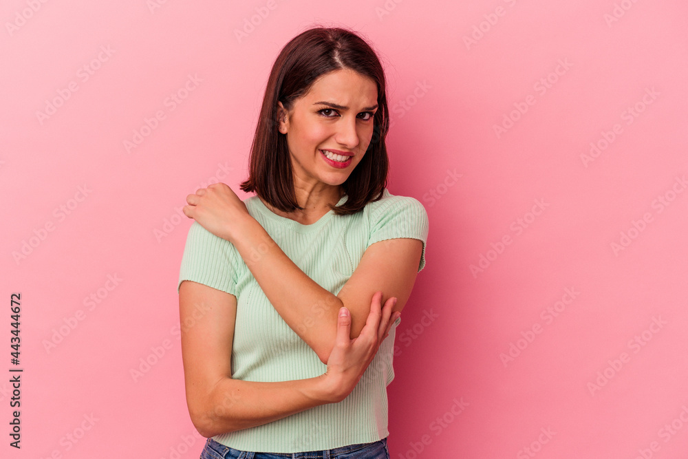 Young caucasian woman isolated on pink background massaging elbow, suffering after a bad movement. Young caucasian woman isolated on pink background massaging elbow, suffering after a bad movement.