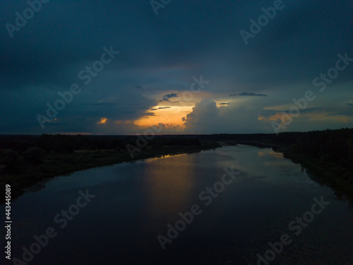 Drone view of a beautiful, mesmerizing sunset with clouds over a lake, a river on a summer evening