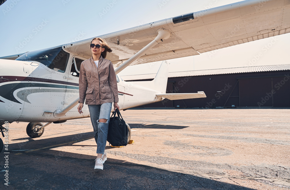 Obraz premium Charming young woman walking down the airfield