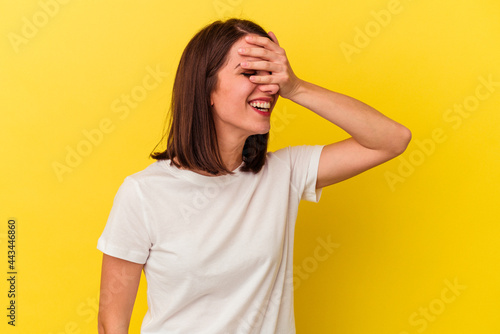 Bild auf Leinwand Young caucasian woman isolated on yellow background covers eyes with hands, smiles broadly waiting for a surprise