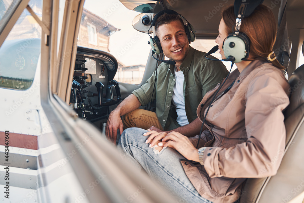 Joyful young man and woman sitting inside plane cockpit Joyful young man and woman sitting inside plane cockpit