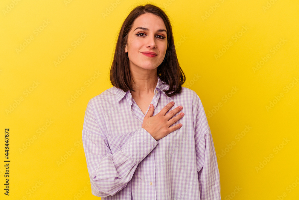 Young caucasian woman isolated on yellow background taking an oath, putting hand on chest. Young caucasian woman isolated on yellow background taking an oath, putting hand on chest.