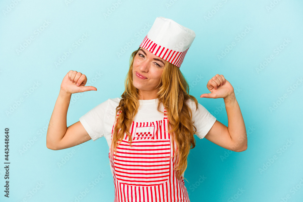 Caucasian ice cream maker woman isolated on blue background feels proud and self confident, example to follow. Caucasian ice cream maker woman isolated on blue background feels proud and self confident, example to follow.
