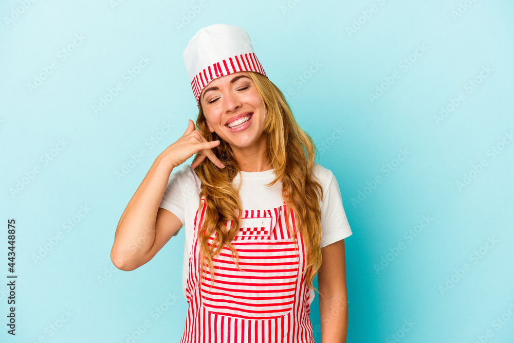 Caucasian ice cream maker woman isolated on blue background showing a mobile phone call gesture with fingers. Caucasian ice cream maker woman isolated on blue background showing a mobile phone call gesture with fingers.