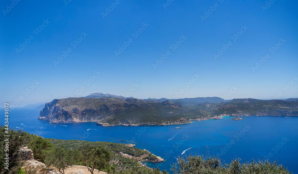 View of Mallorca island from Sa Dragonera island with Tramuntana mountain range visible. Aerial view of coast and boats in summer destination at the sea. Idyllic travel vacation on the beach