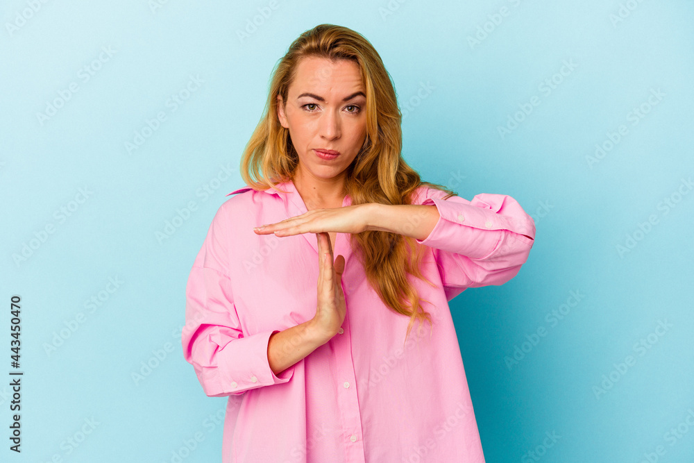 Caucasian woman isolated on blue background showing a timeout gesture. Caucasian woman isolated on blue background showing a timeout gesture.